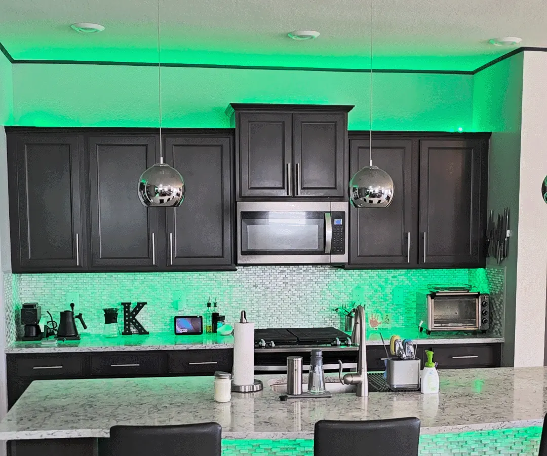 Kitchen accent lights glowing green as a subtle laundry notification in Bryan's home.